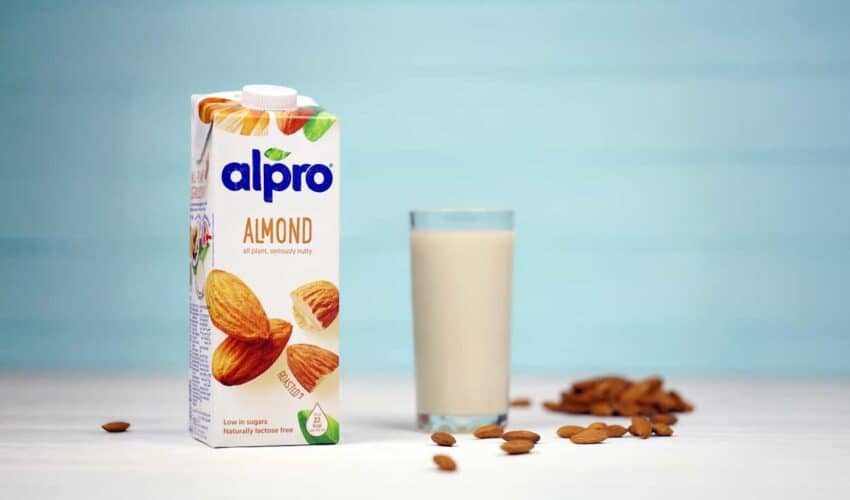 Das Bild zeigt eine Packung Alpro Mandelmilch und ein Glas mit besagter Milch.