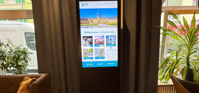 Digitale Stele mit touristischen Informationen über Karlsruhe in der Lobby des Hotels Ambassador.