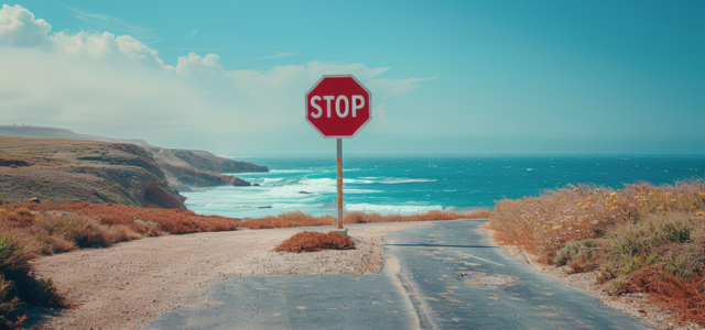 Stoppschild vor Meer an Ende von Straße