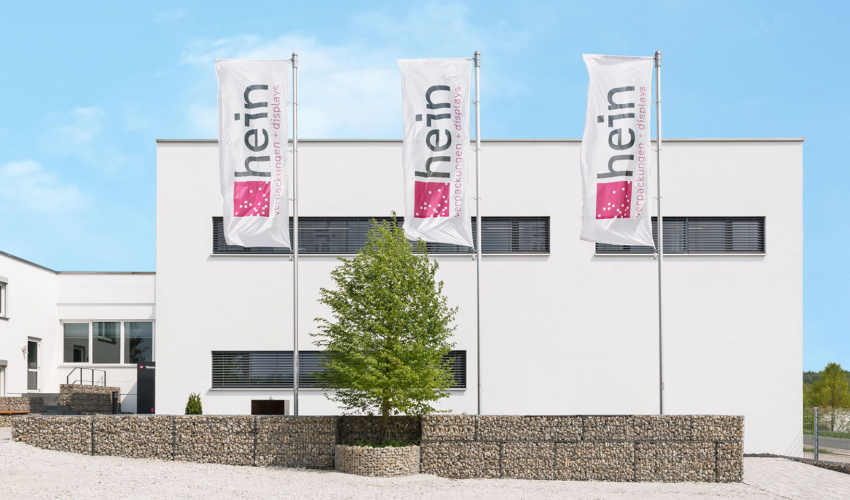 Hauptsitz Hein Verpackungen mit drei Fahnen mit Unternehmenslogo