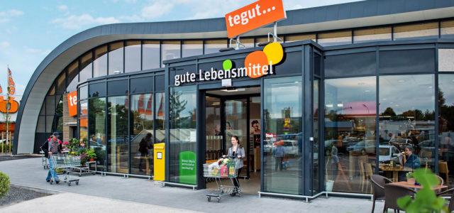 Kundin kommt mit Einkaufswagen aus tegut-Filiale