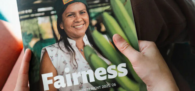 Hand hält Schild mit Aufschrift "Fairness" und einer Frau mit Bannen
