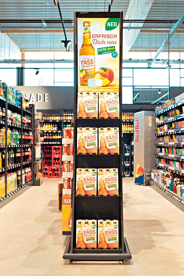 emsu_spotlightone Mit Fassbrause befülltes Display Spotlight One in Getränkeabteilung von Supermarkt