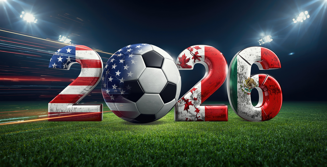 Schriftzug "2026" in den Farben der Flaggen von USA, Mexiko und Kanada und mit Fußball