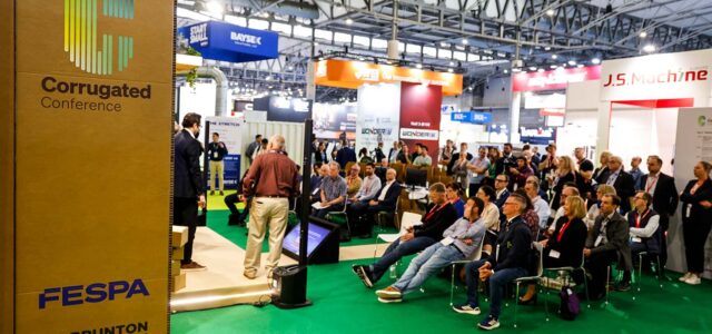 Vortragsraum der Corrugated mit Publikum und Aufsteller aus Wellpappe
