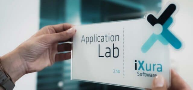 Zwei Hände halten Schild hoch mit Aufschrift "Application Lab"