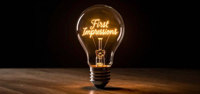 Glühbirne auf Tisch mit Glühfaden mit den Worten "First Impressions"