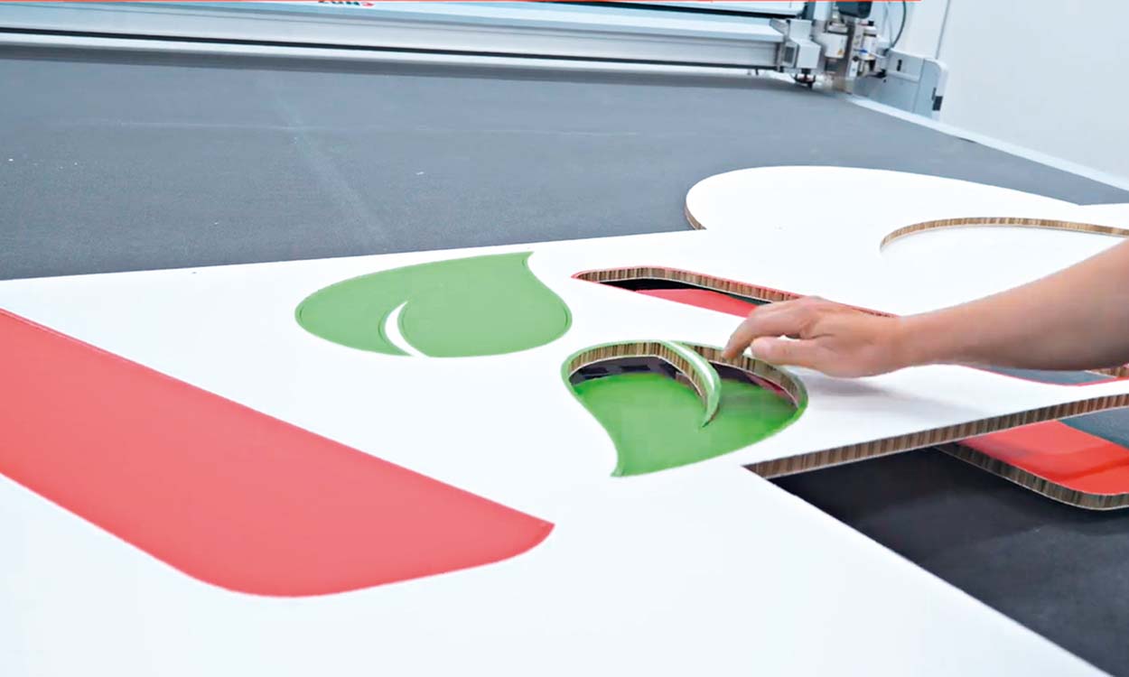 zuend_systemtechnikcut_re_board Mitarbeiter bearbeitet ausgeschnittenes Display auf Arbeitstisch